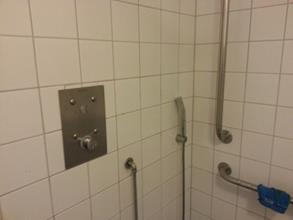 Einfache aber robuste Duschamaturen und angebrachte Haltestangen sorgen für Sicherheit.